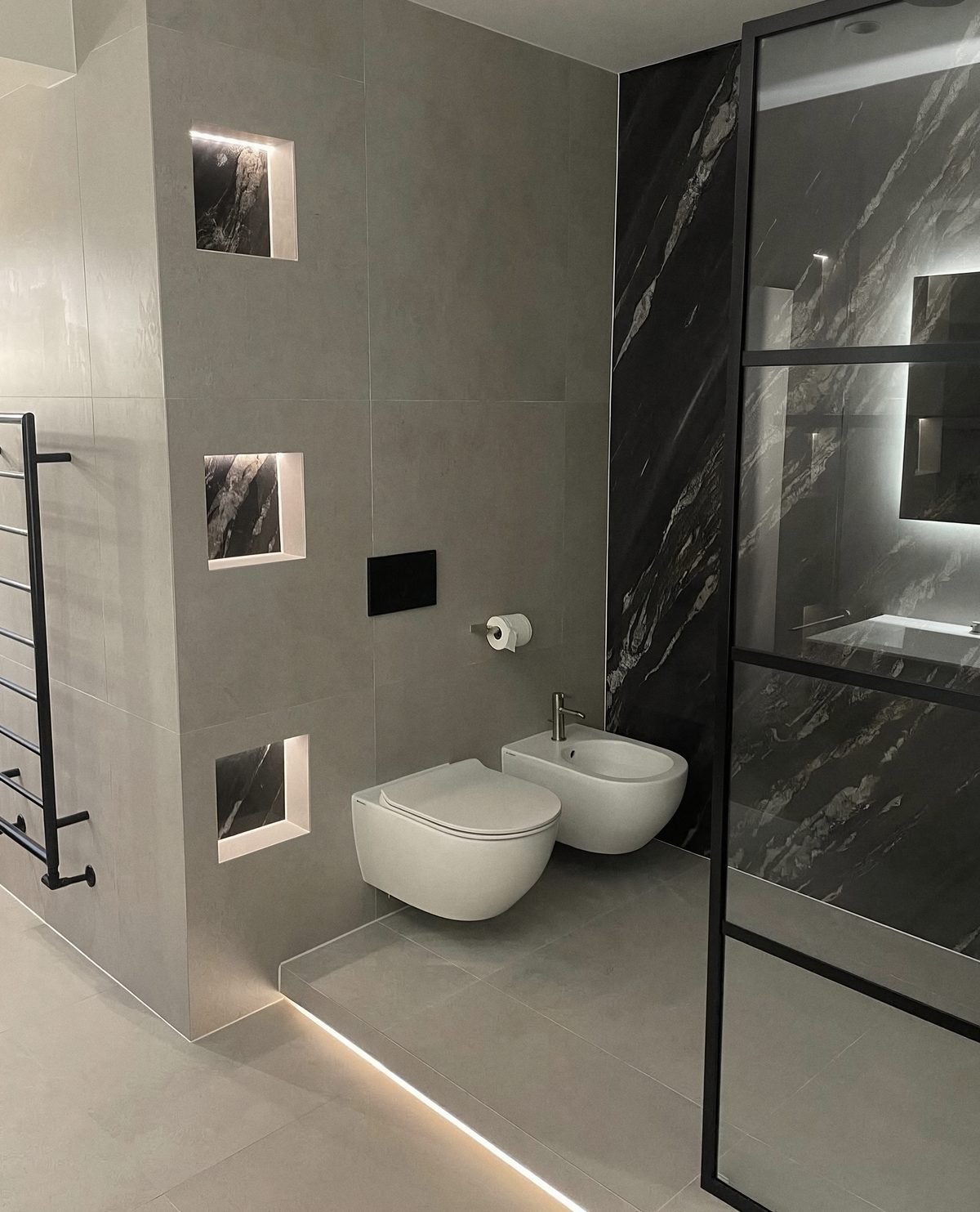 Grey stone bathroom with backlit niches