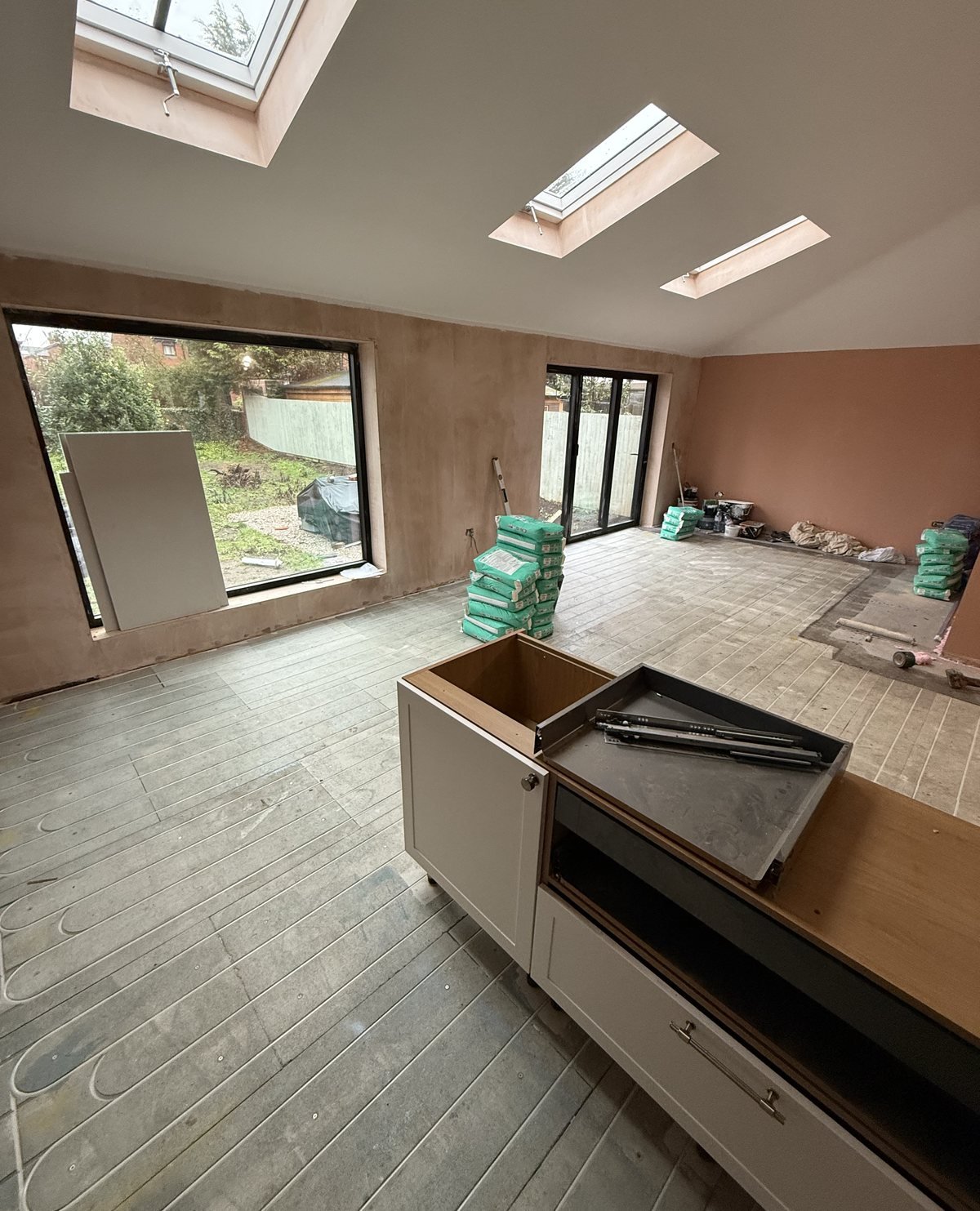 Kitchen-diner extension mid-build: bare walls and the floor being prepared, before tiling and brick slip