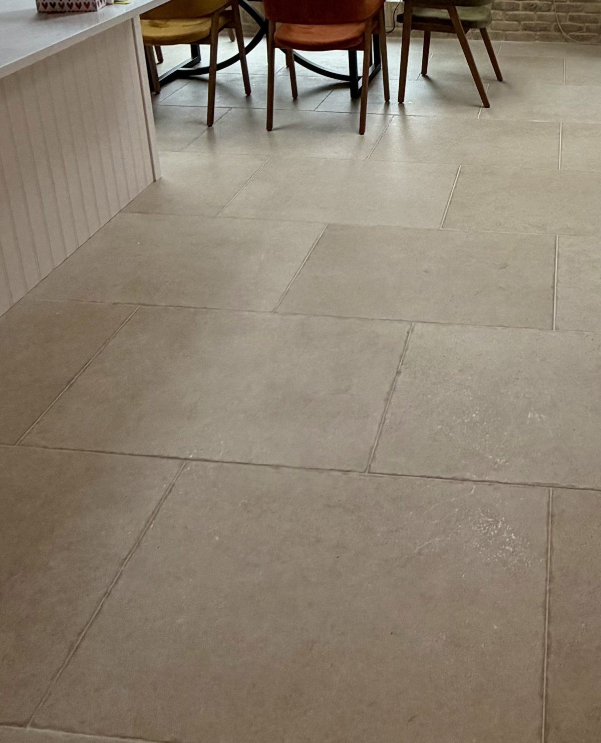 Large-format stone-effect floor tiles through a kitchen-diner extension