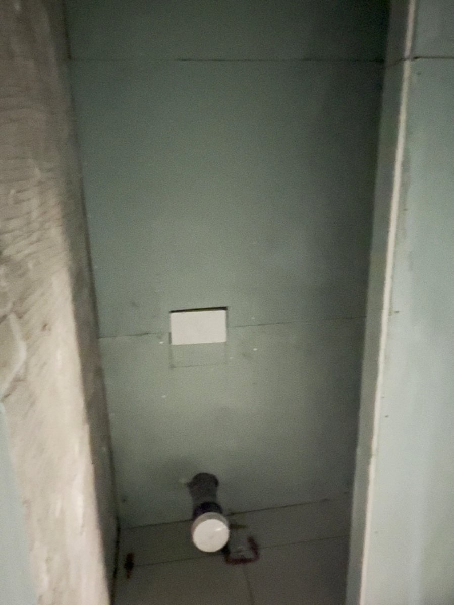 WC wall before tiling, boarded and tanked with the flush plate opening and waste outlet